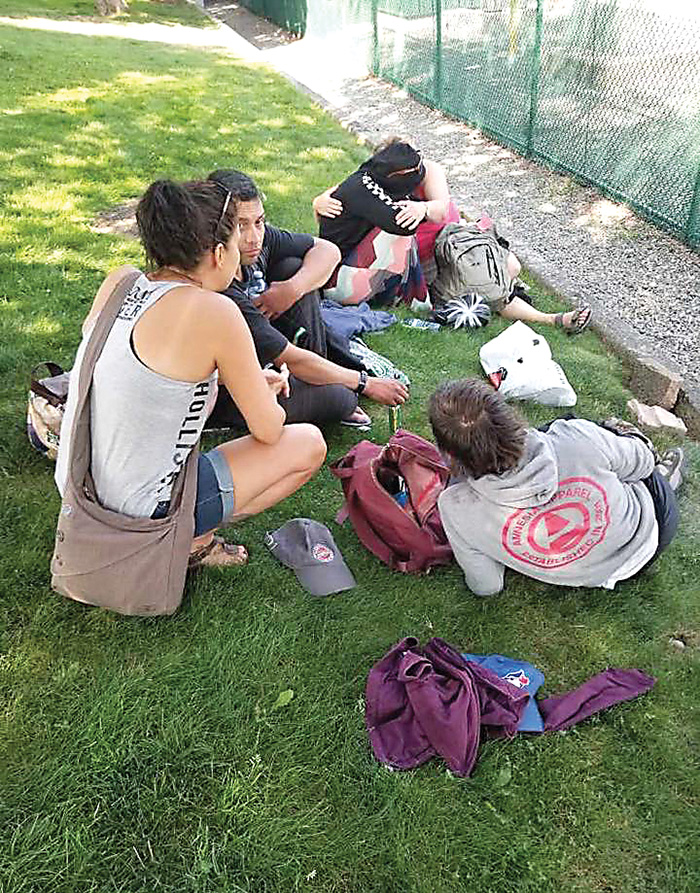 Khristina Lawless speaking with people who she has given backpacks to from her first trip in Chilliwack, in summer 2019.